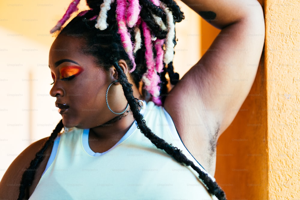a woman with pink and black dreadlocks on her head