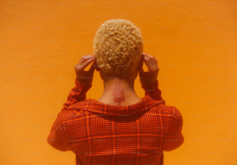 a woman in a red sweater with her back to the camera