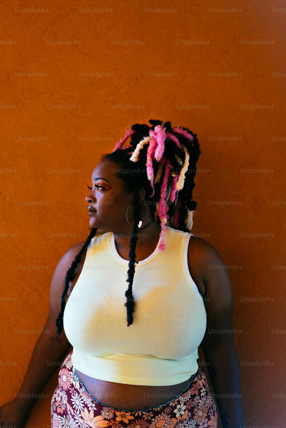 a woman with dreadlocks standing against a wall