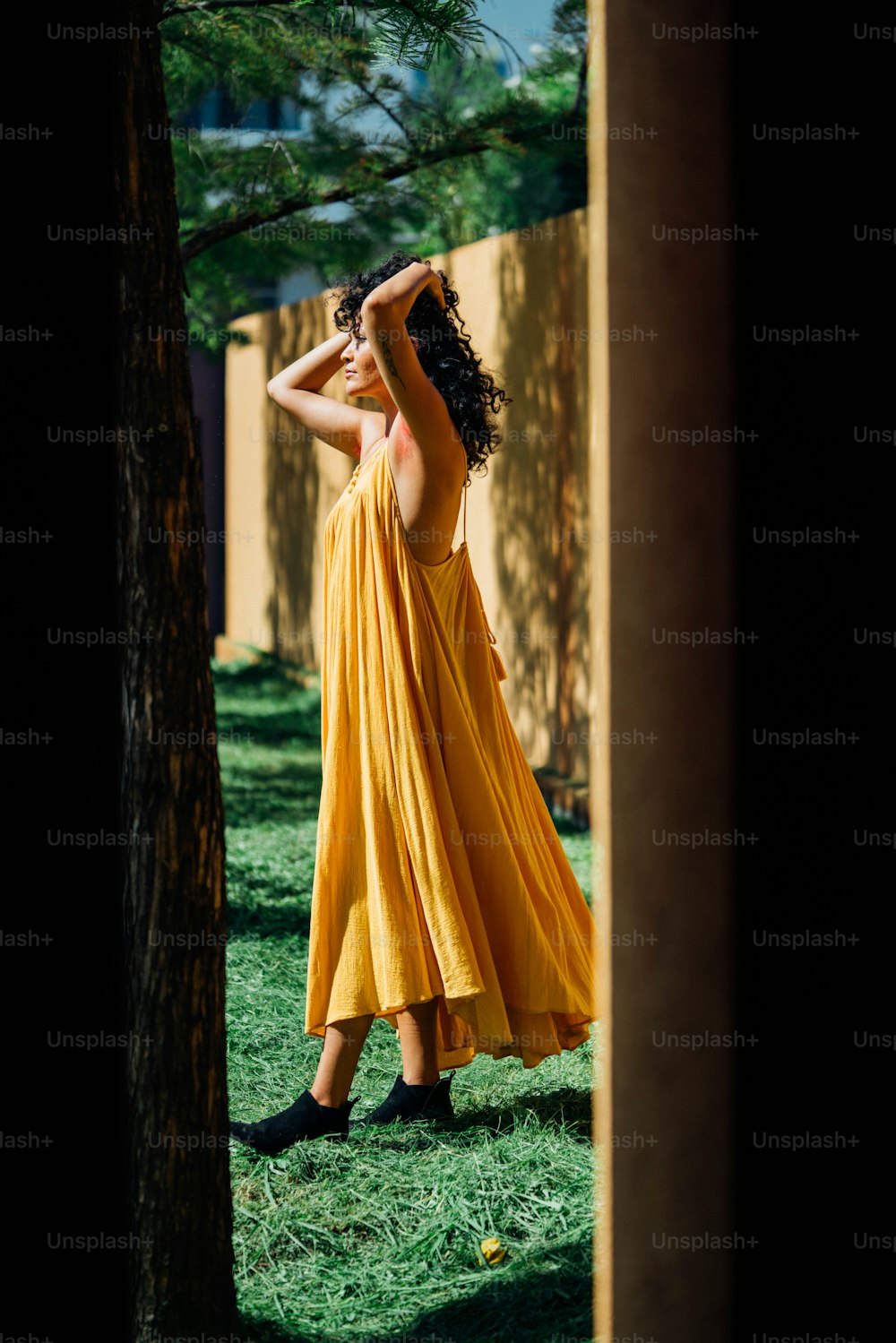 a woman in a yellow dress standing in the grass