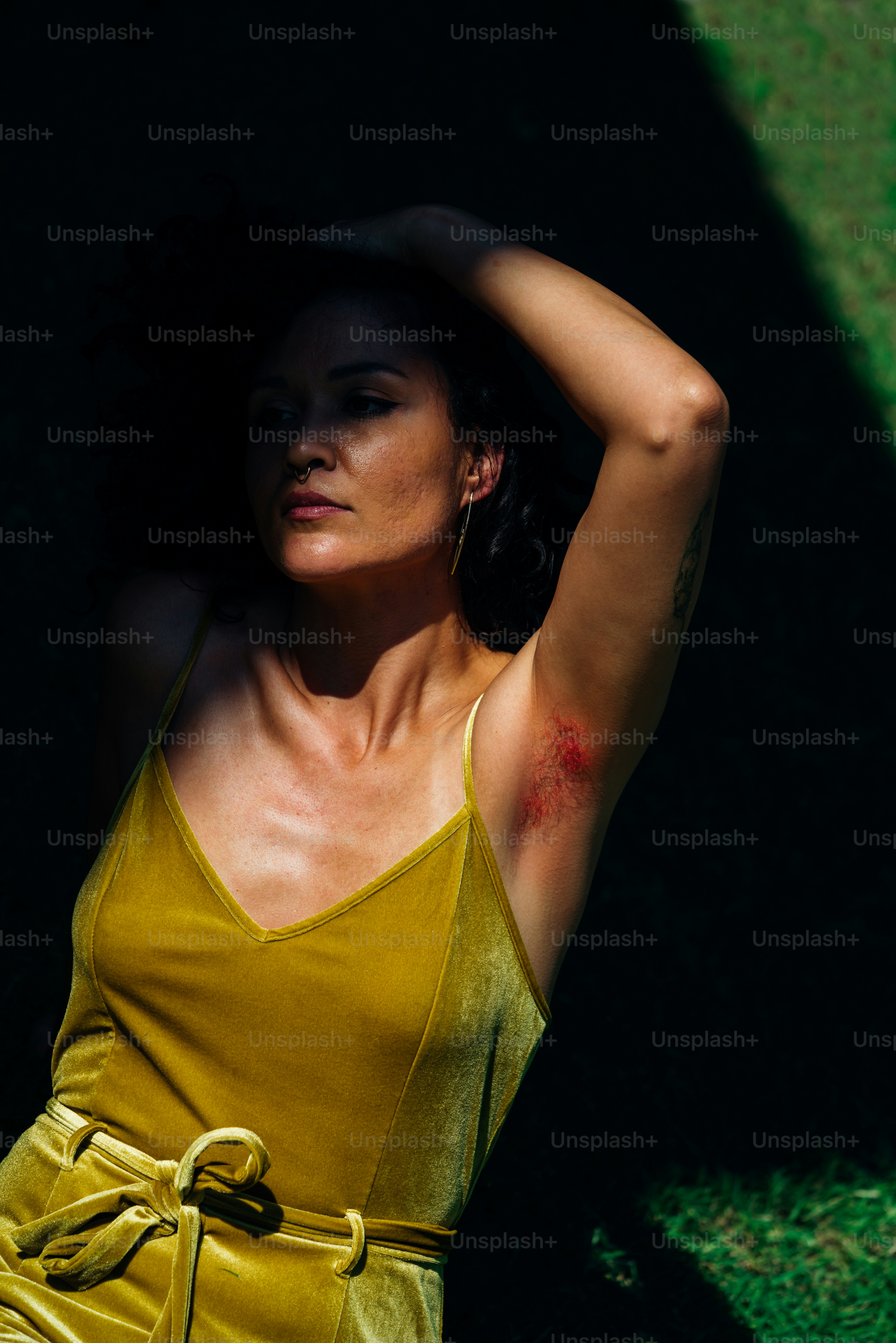 a woman in a yellow dress leaning against a wall