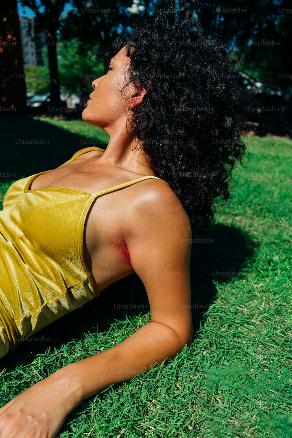 a woman laying on the grass in a yellow dress