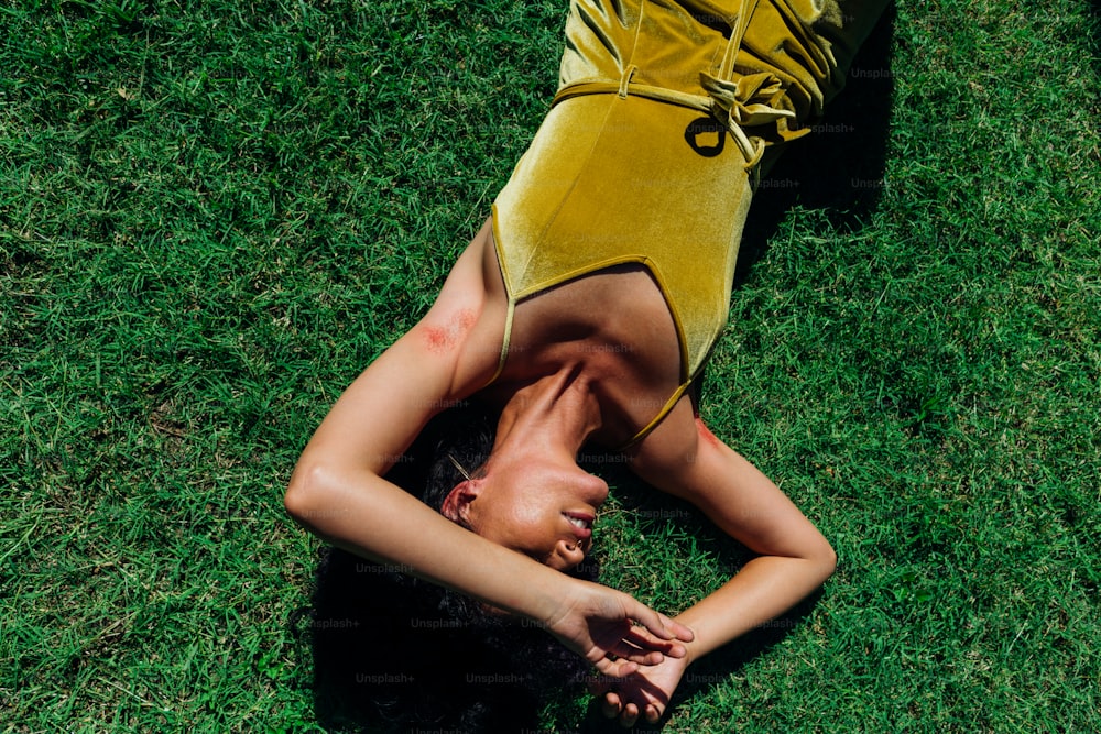 a woman laying on the ground in a yellow dress