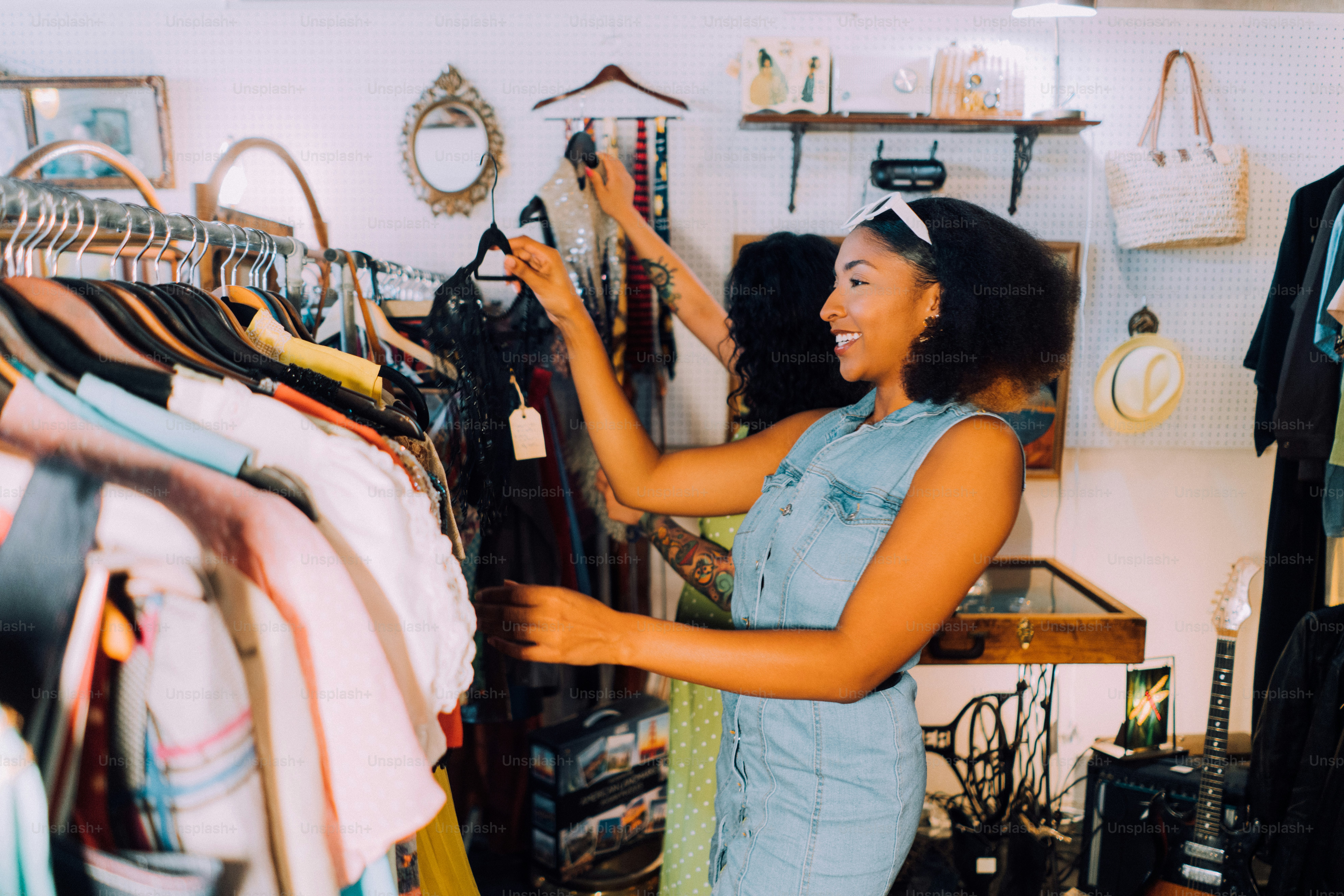 a woman looking at a rack of clothes