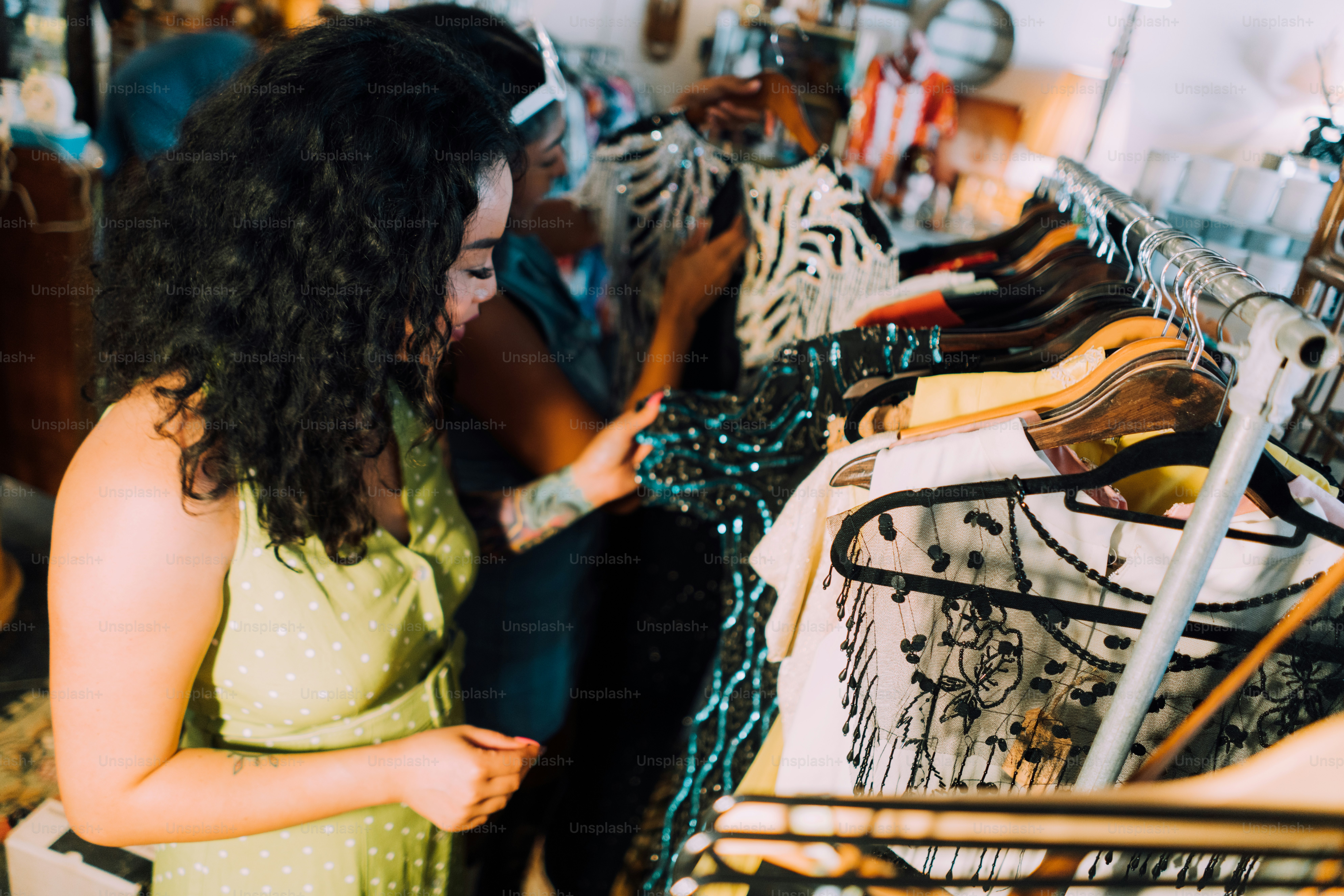 uma mulher em um vestido verde olhando para um rack de roupas