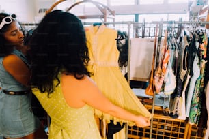 uma mulher olhando para um vestido em um rack