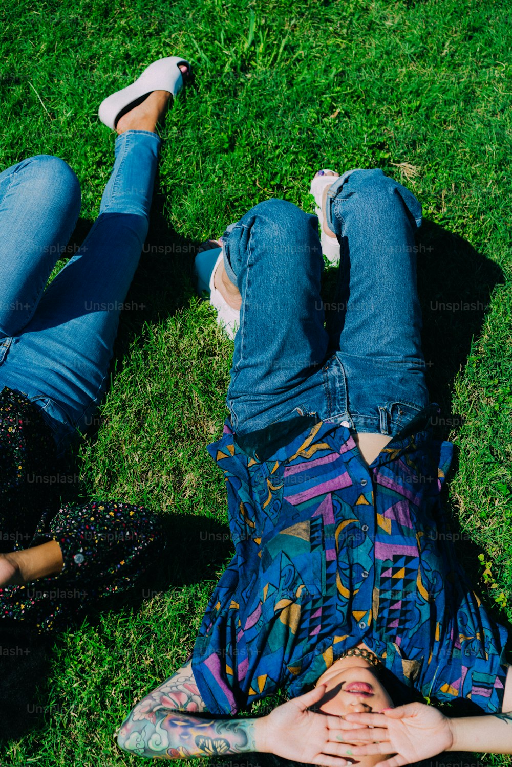 um casal de pessoas deitadas em cima de um campo verde exuberante