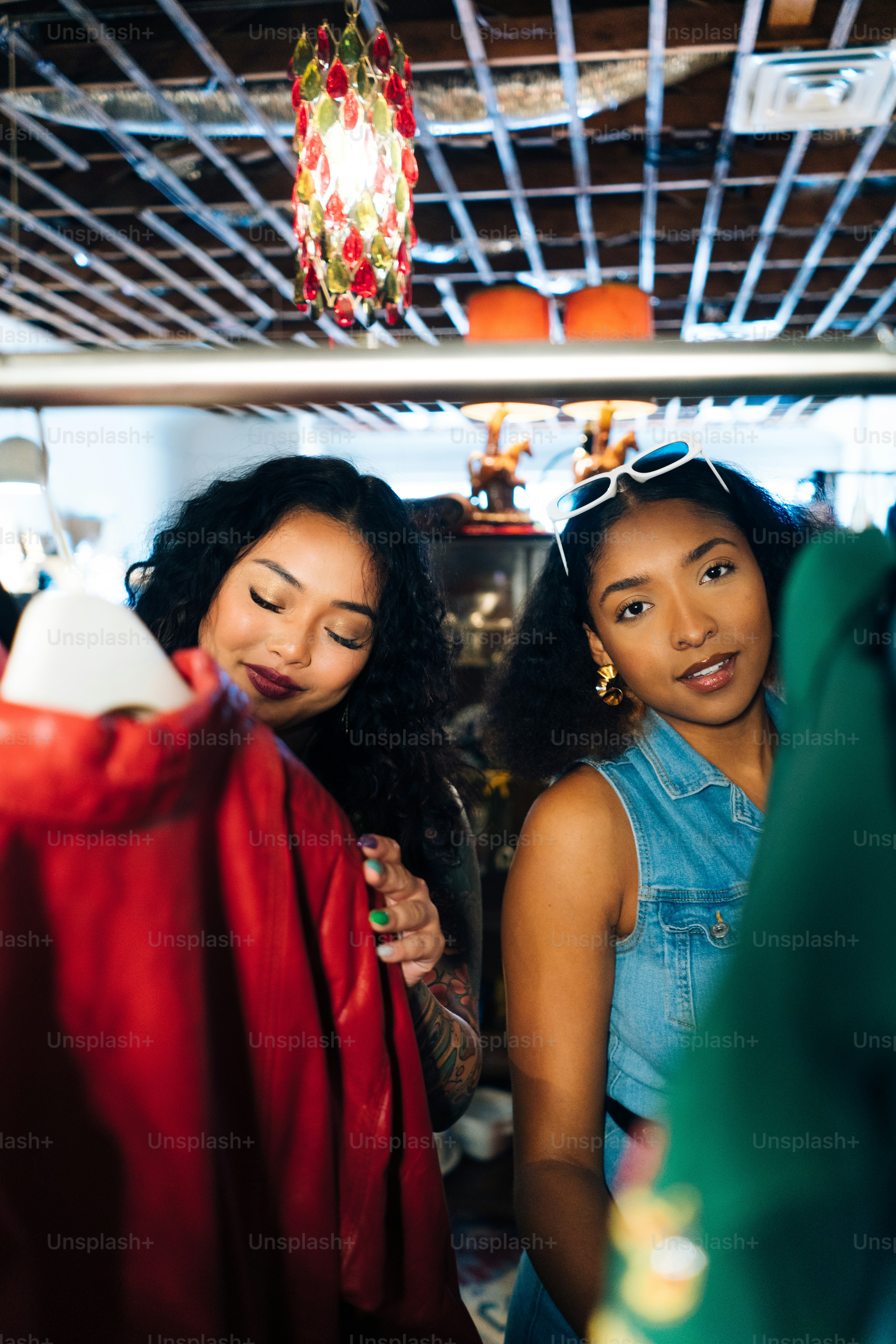 duas mulheres em pé em uma sala olhando para algo