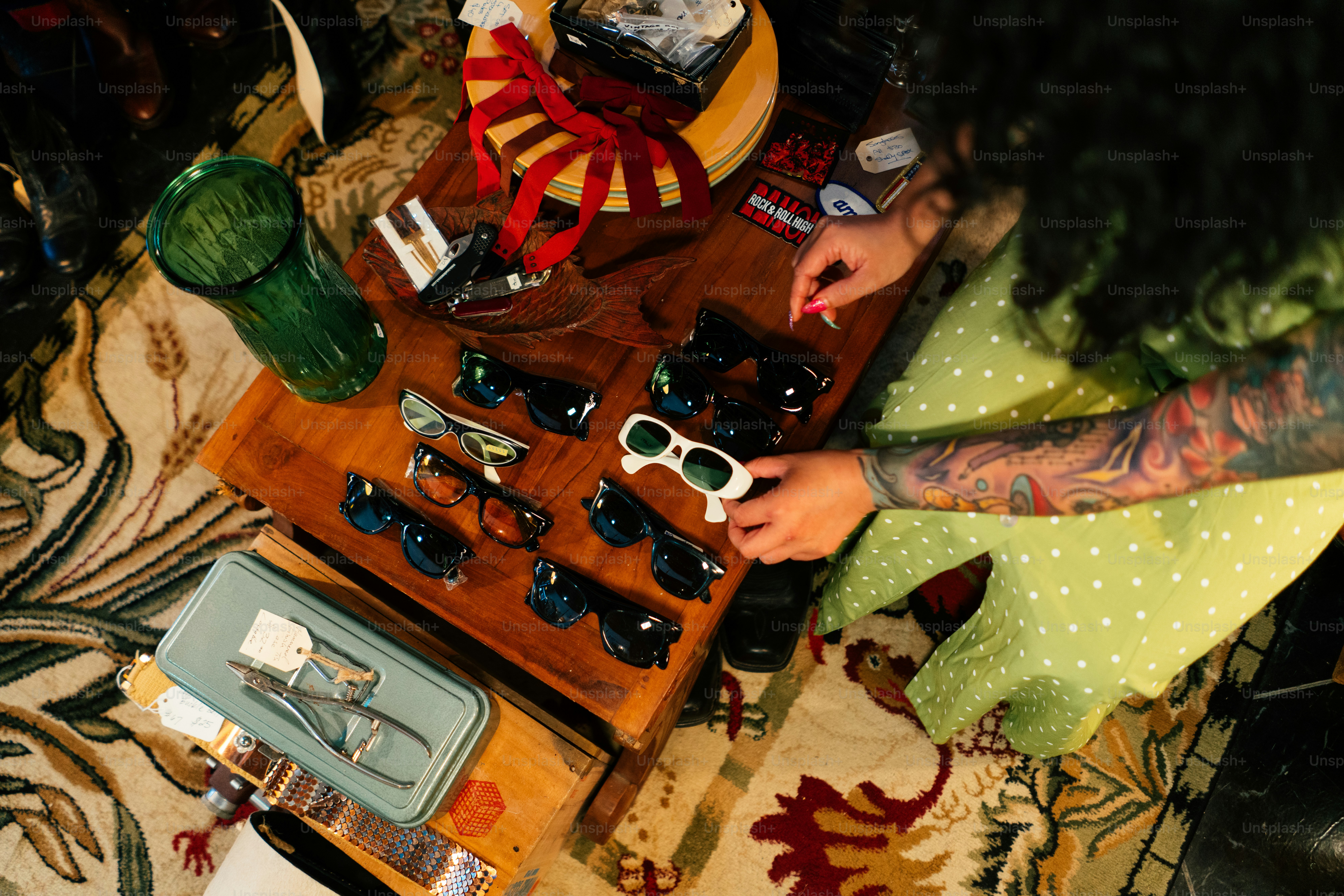 a woman sitting at a table holding a pair of scissors