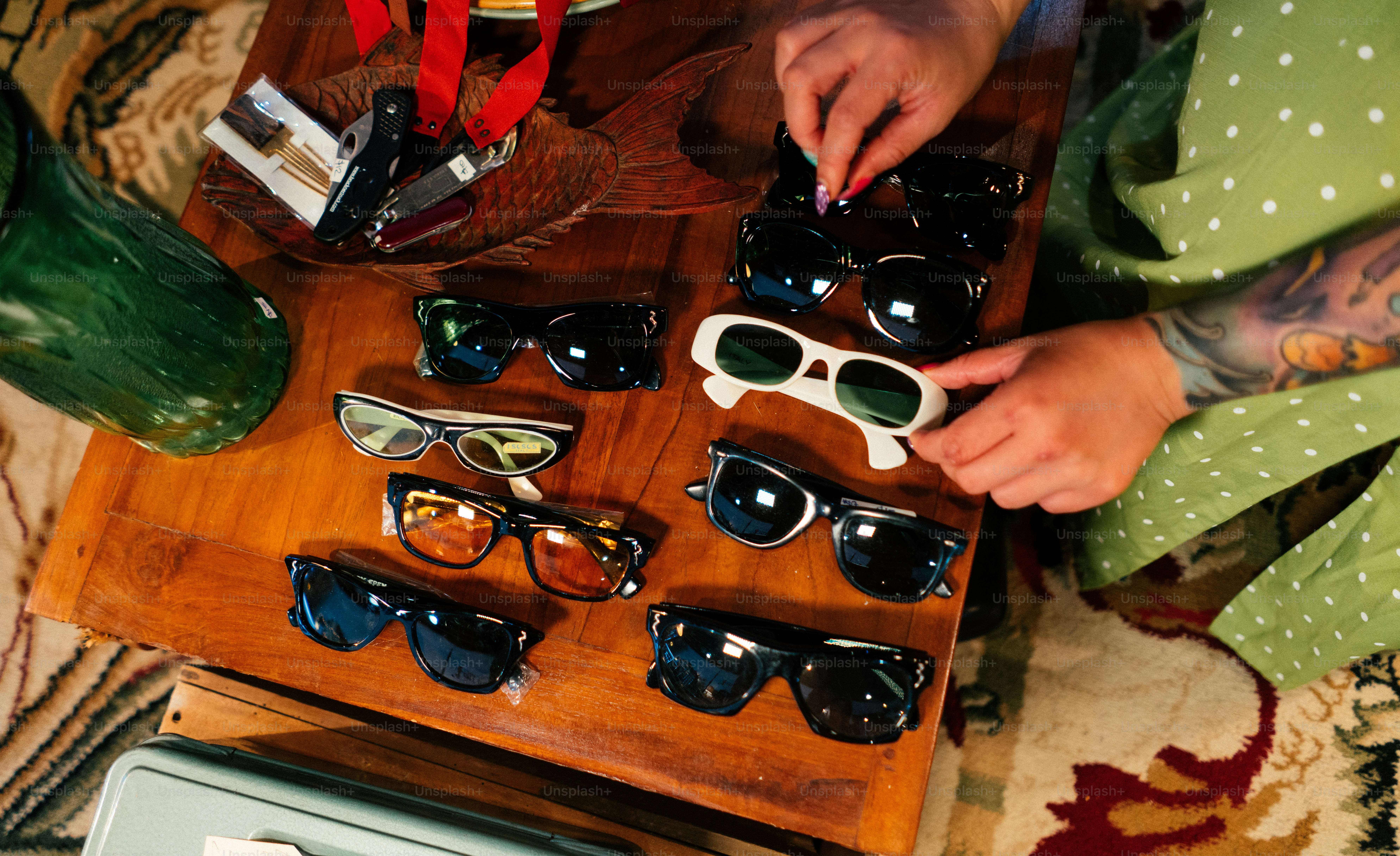 uma mulher está colocando óculos escuros em uma mesa