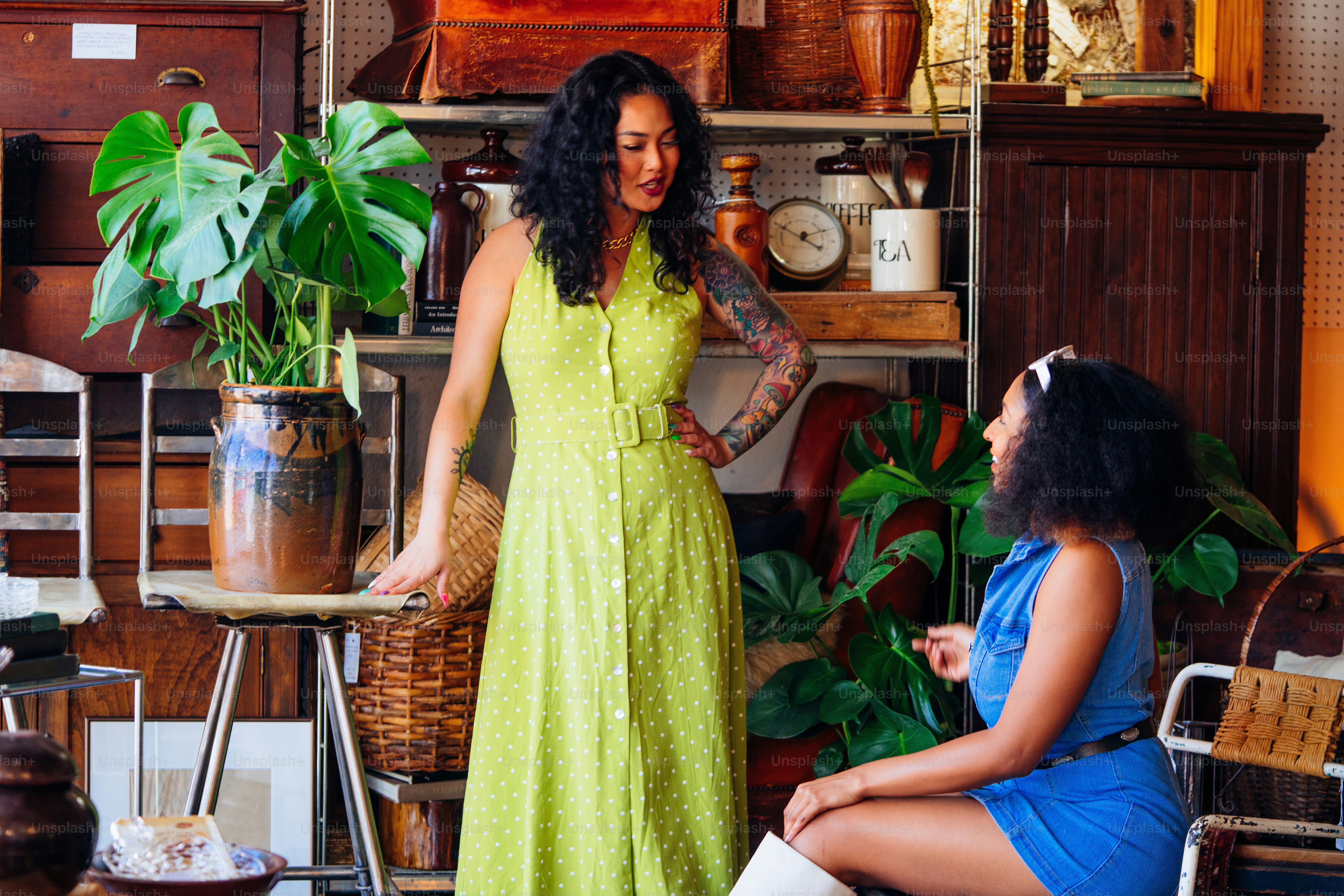 uma mulher em um vestido verde ao lado de uma mulher em um vestido azul