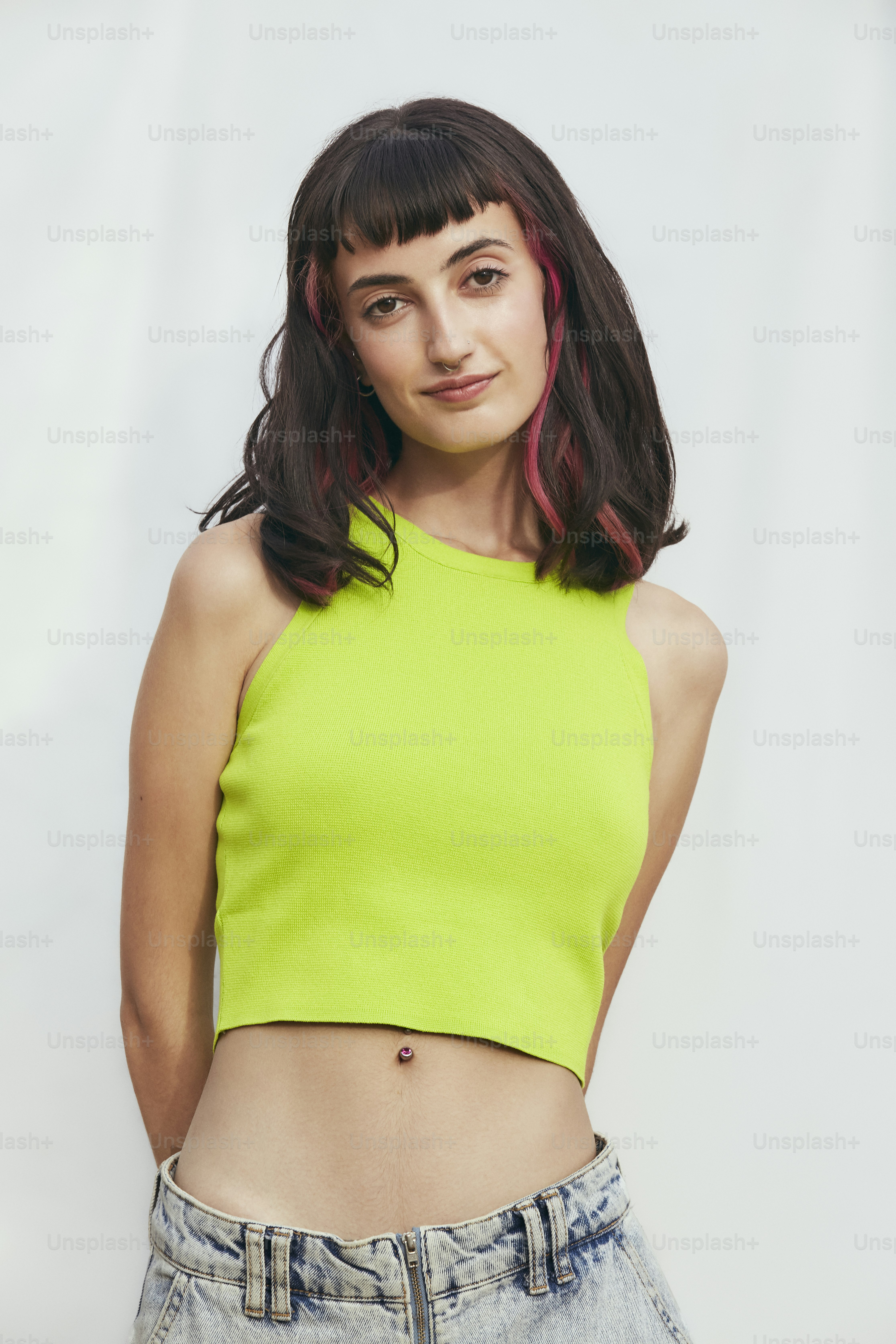 Une femme en haut jaune posant pour une photo