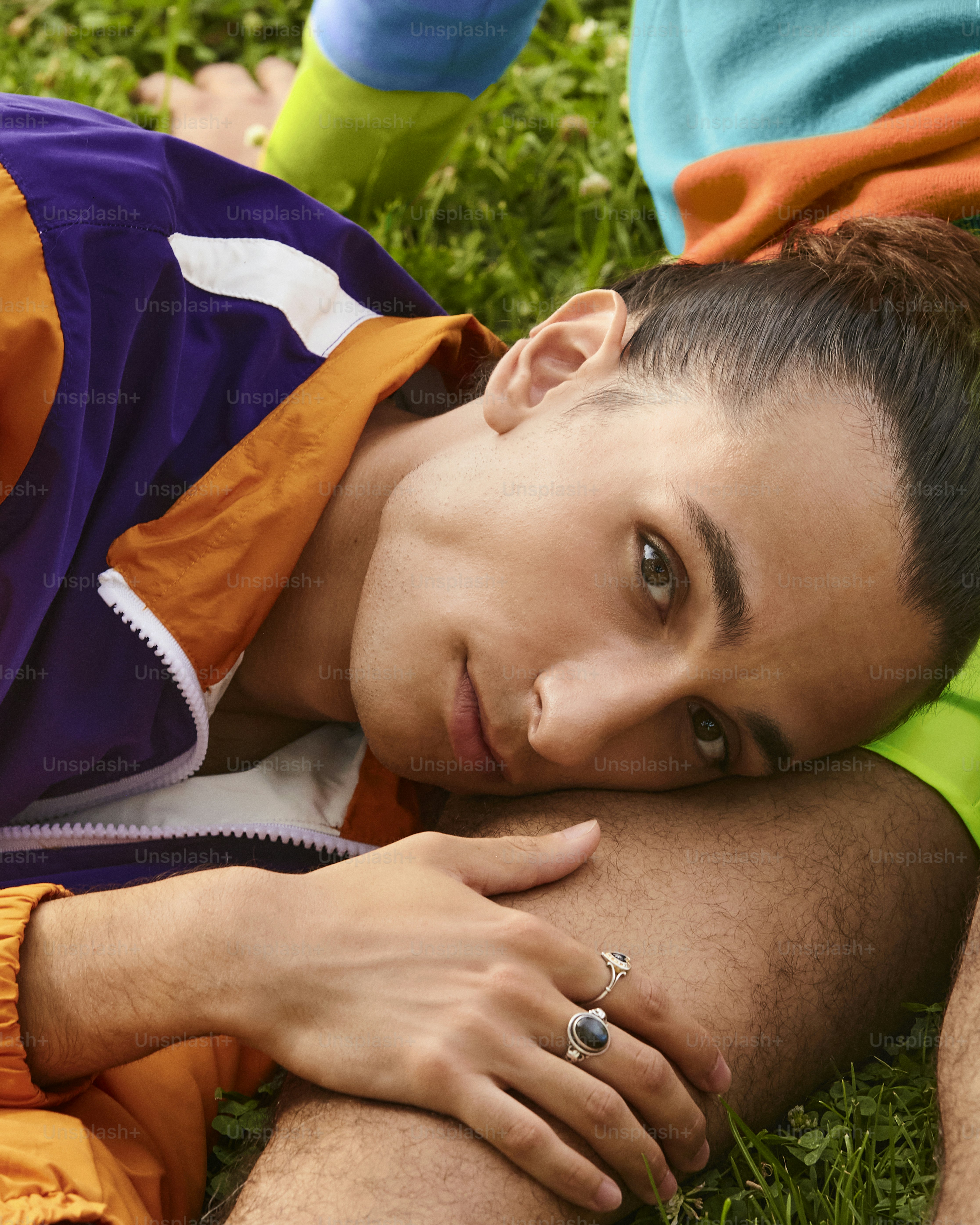 a man laying on the grass with his hand on his chest