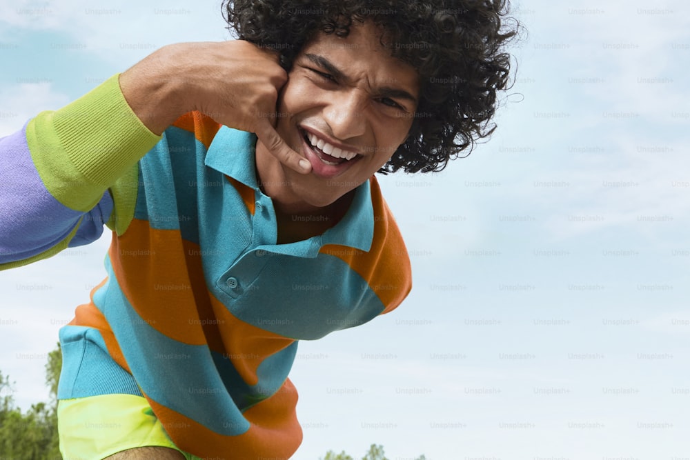 a man with curly hair wearing a colorful shirt