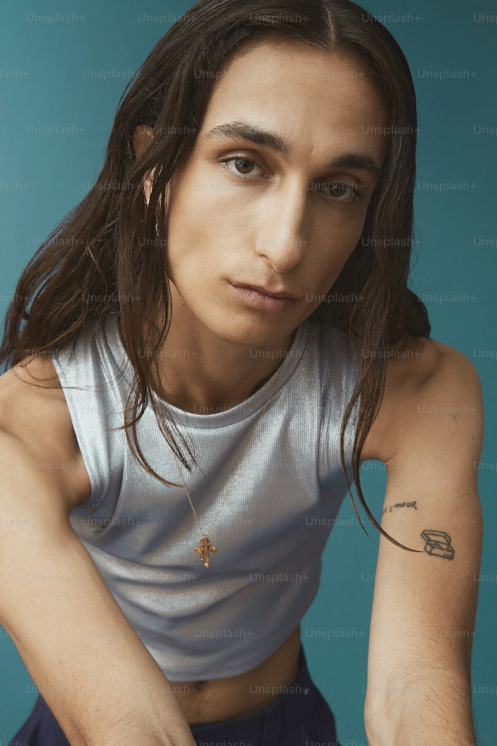 a man with long hair wearing a tank top