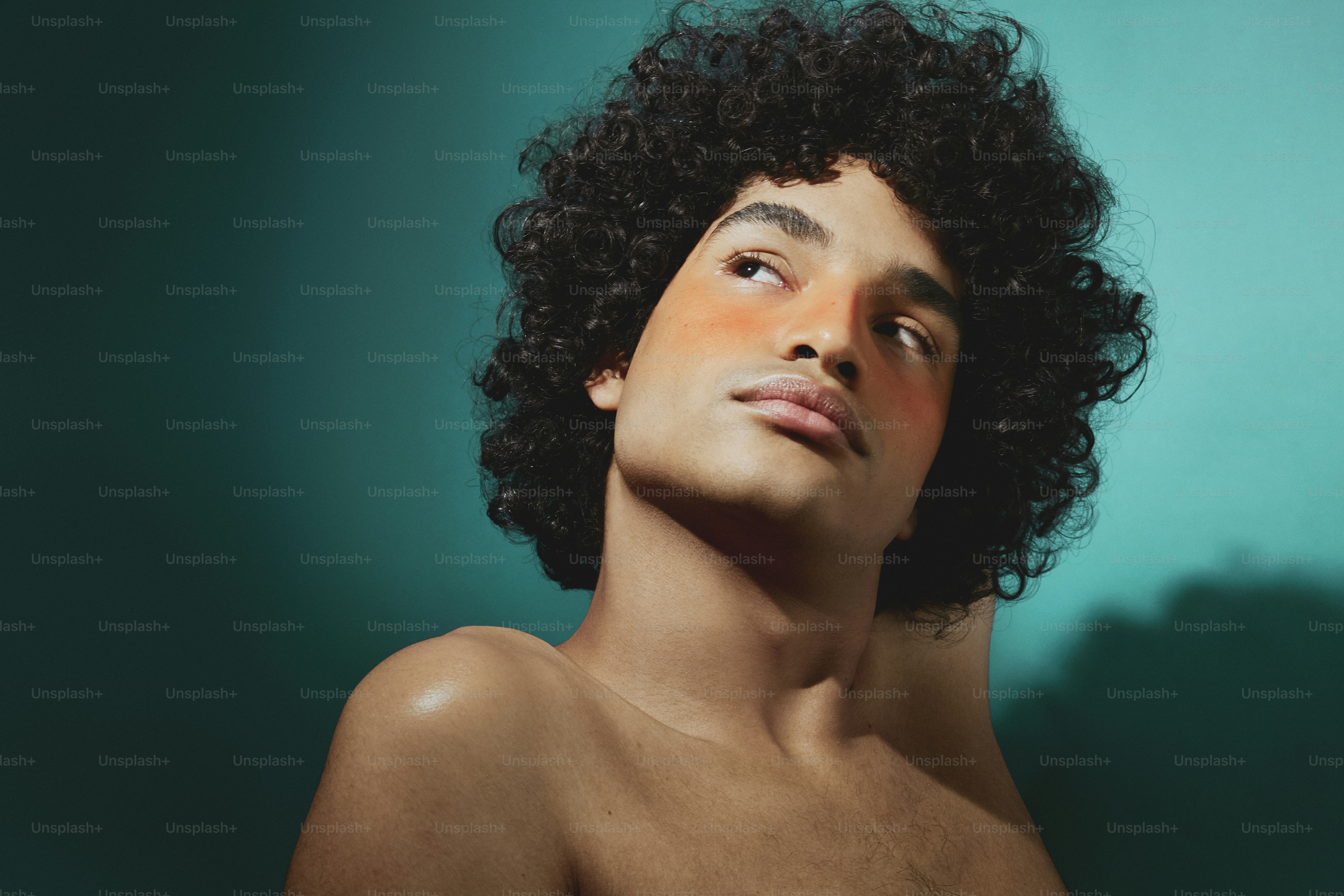 a man with curly hair is looking up