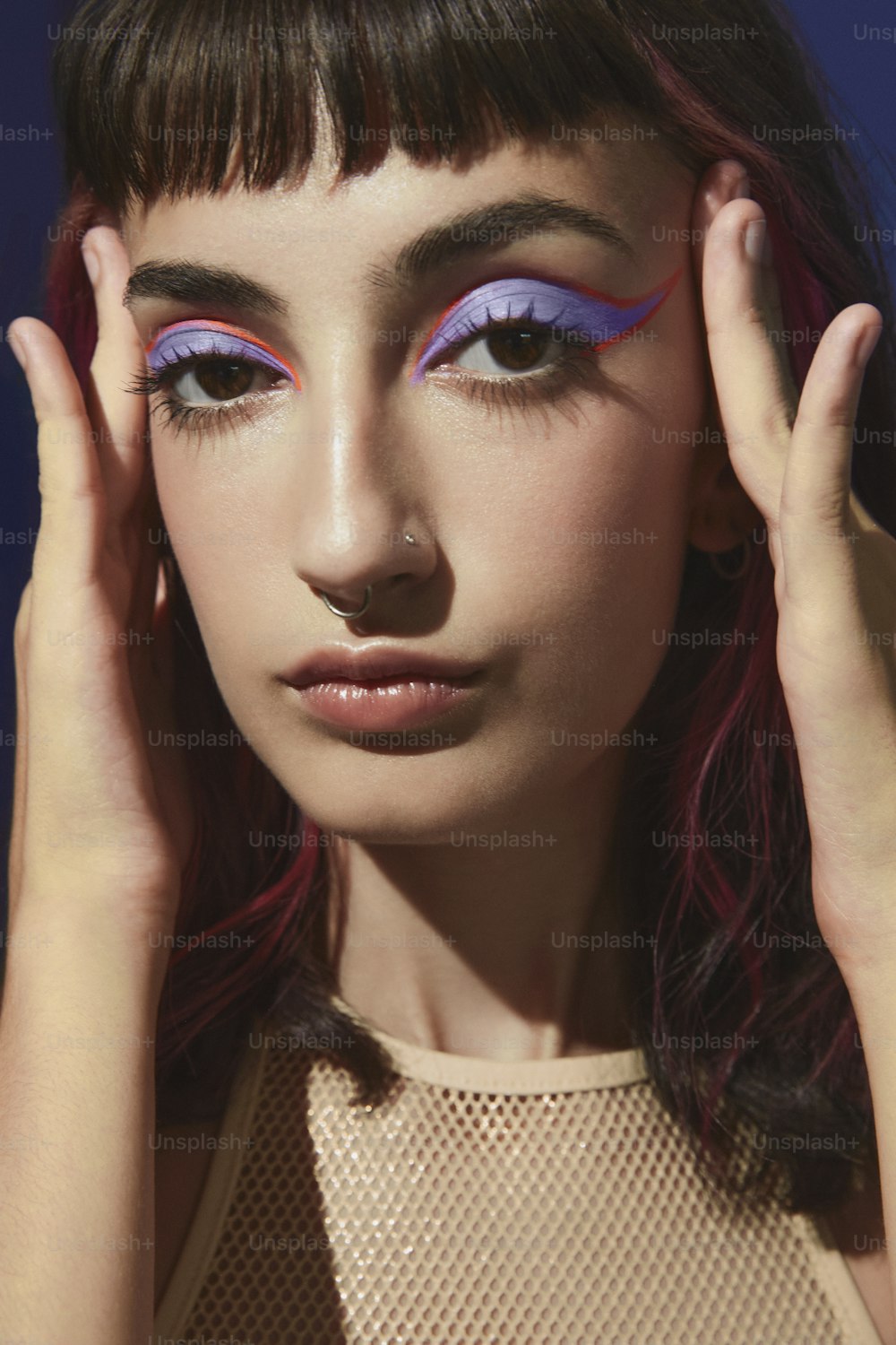 a woman with pink and purple eye makeup