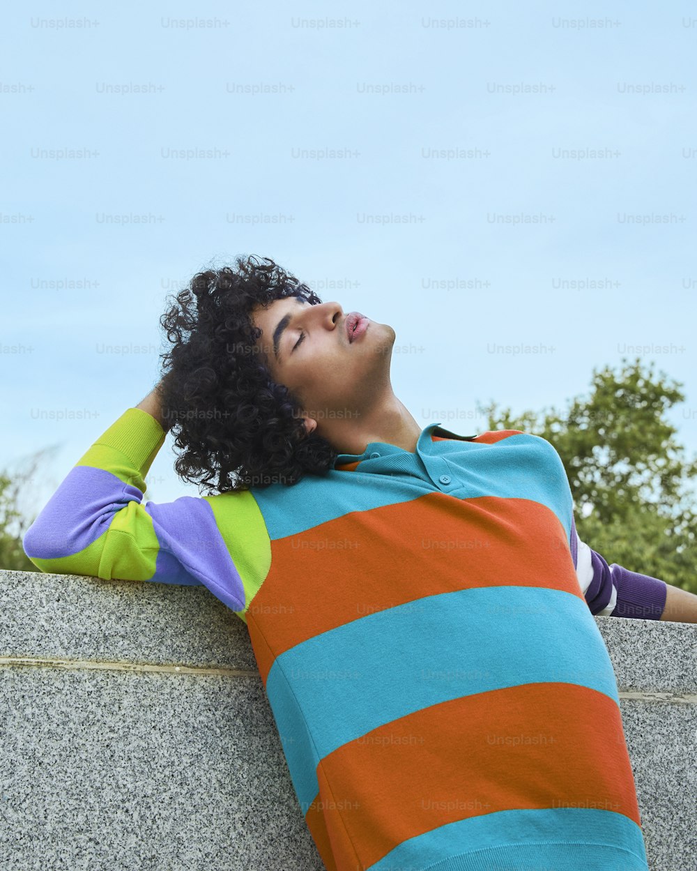 a woman laying on a wall with her eyes closed