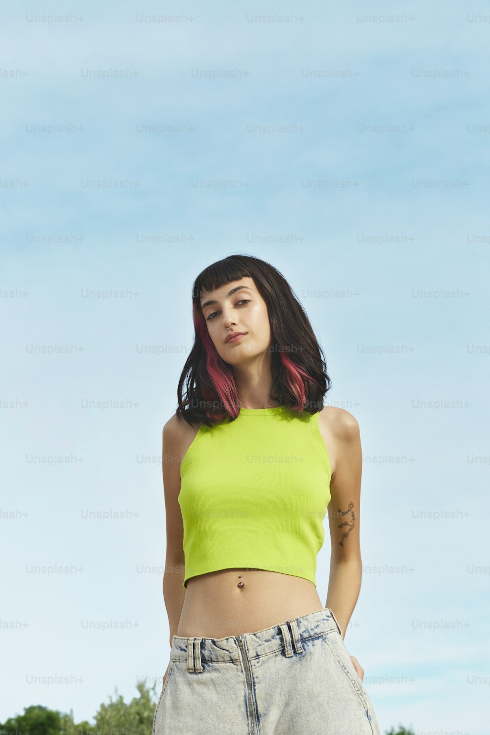 Una mujer con un crop top amarillo posando para una foto