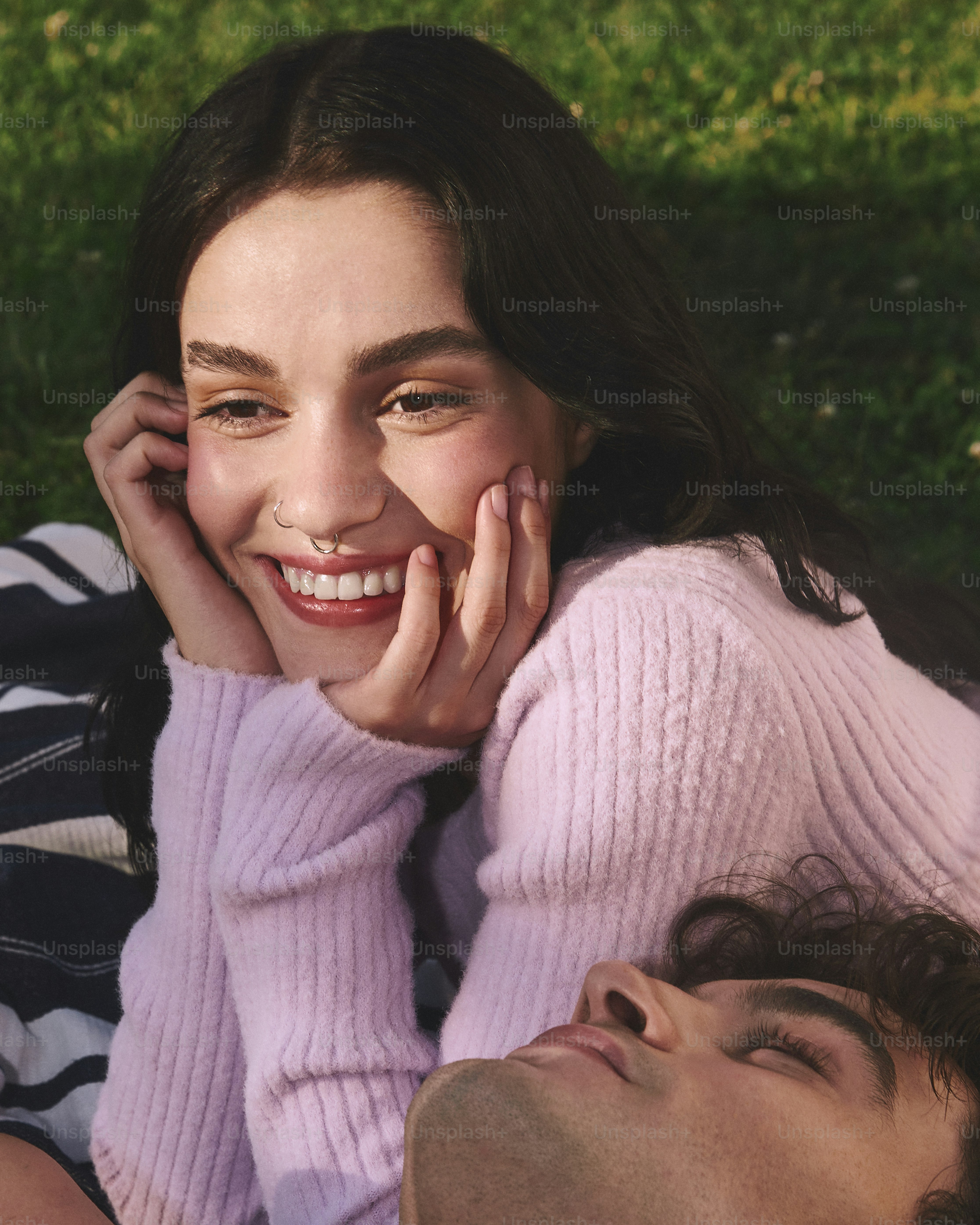 a man and a woman laying on the grass