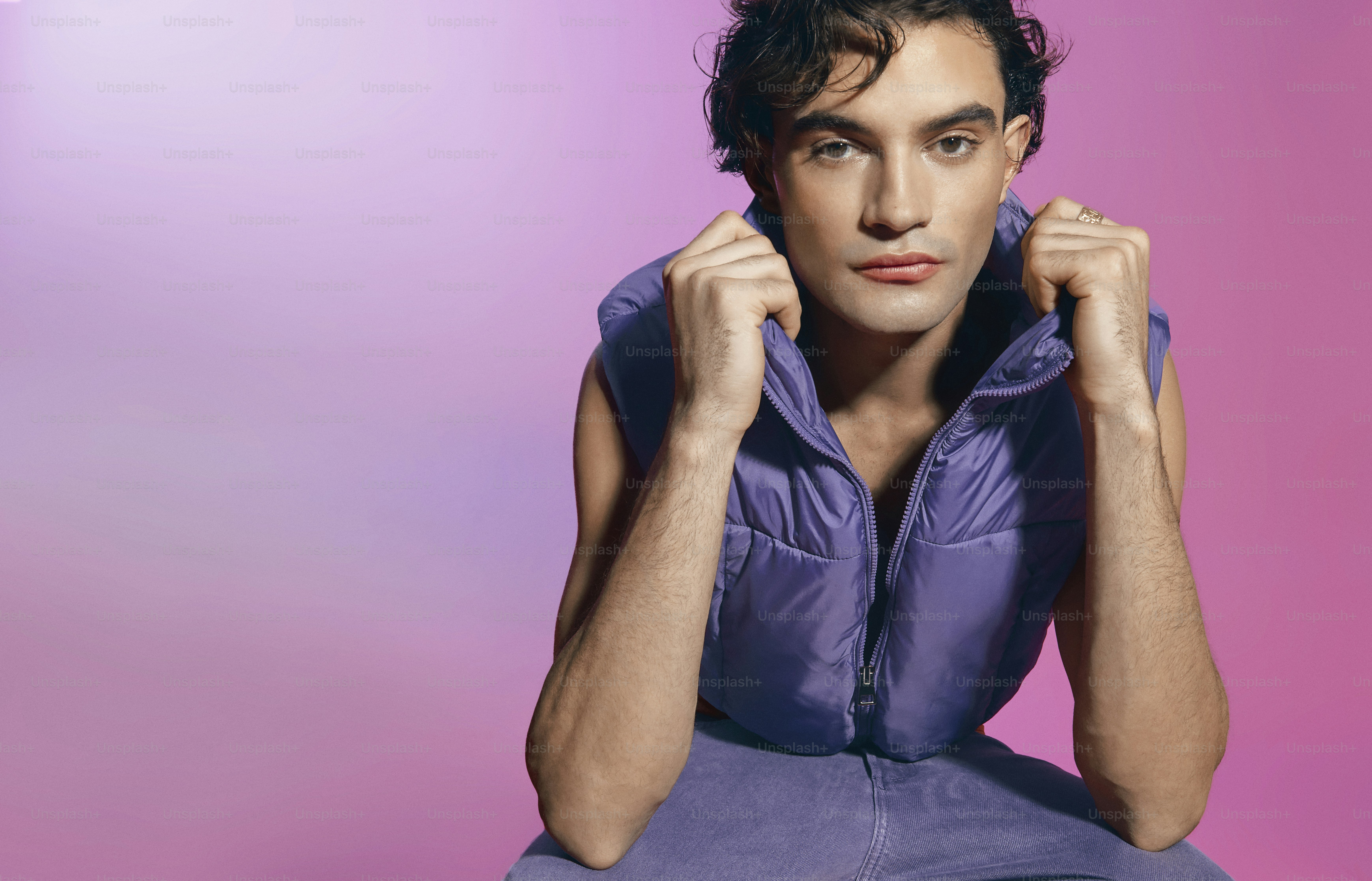 a man sitting on the ground with his hands on his ears