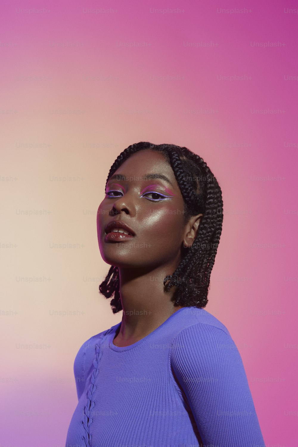 a woman in a purple top with a pink background