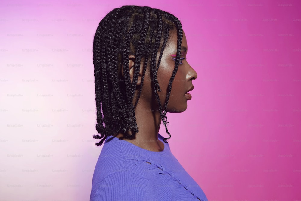 a woman with a purple shirt and a pink background