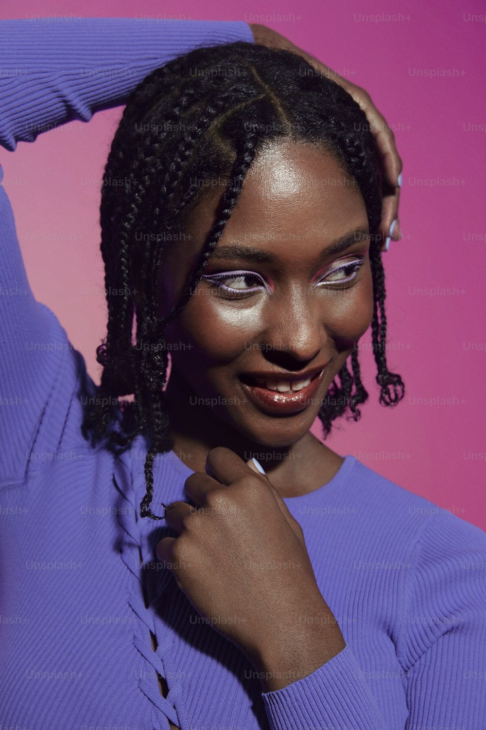 a woman with a purple sweater and a pink background