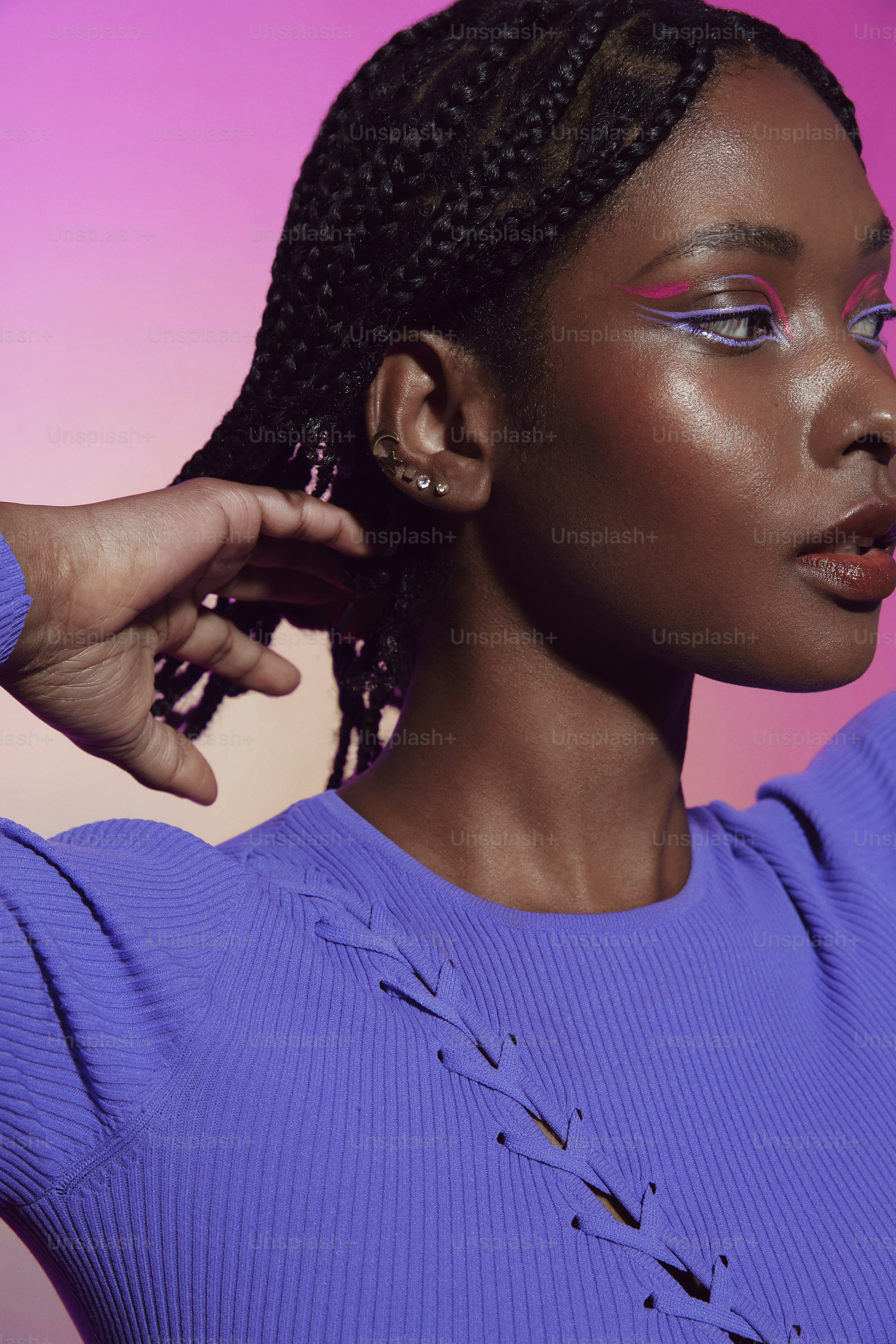 a woman with purple makeup and a purple sweater