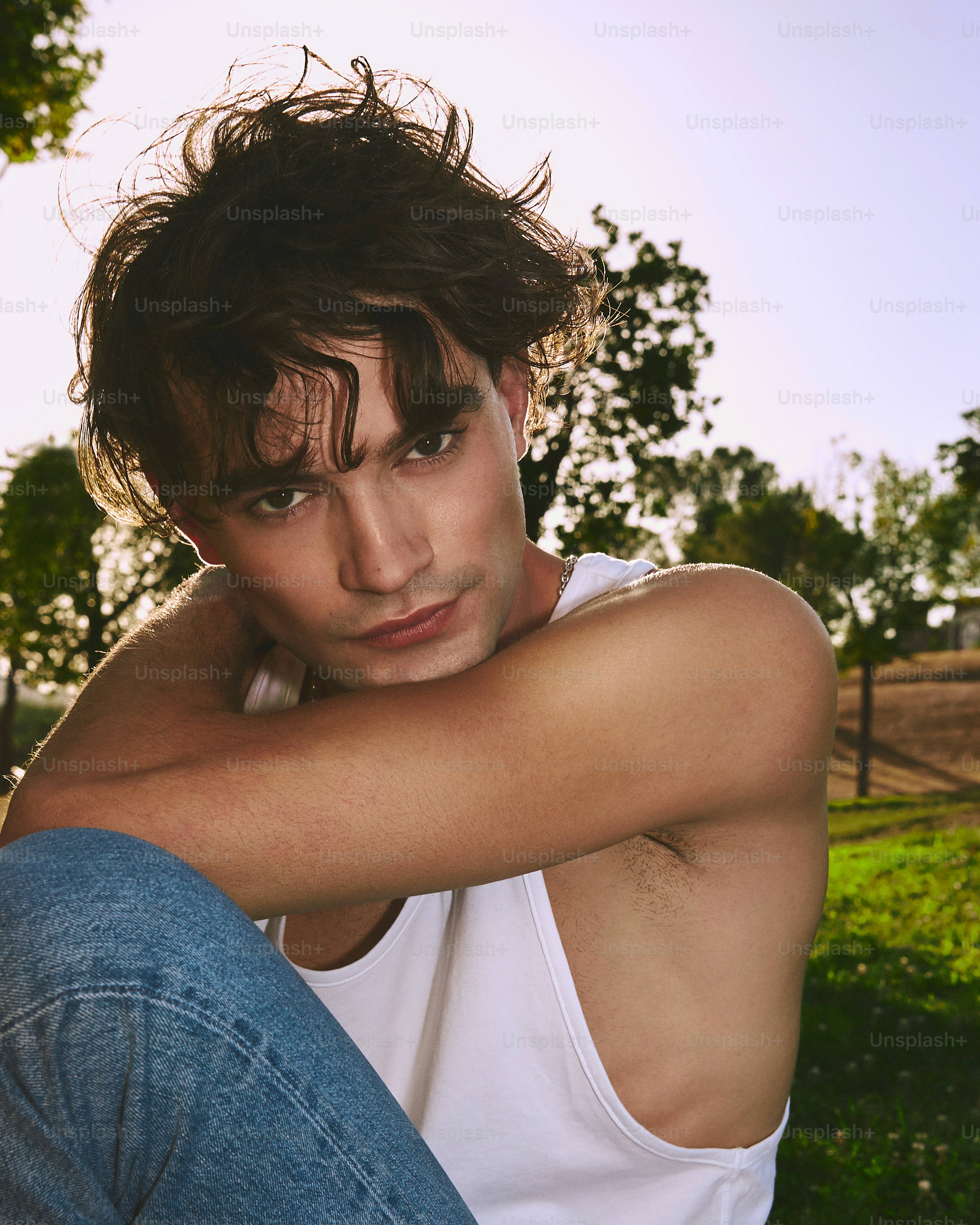 Un joven sentado en el suelo con los brazos cruzados