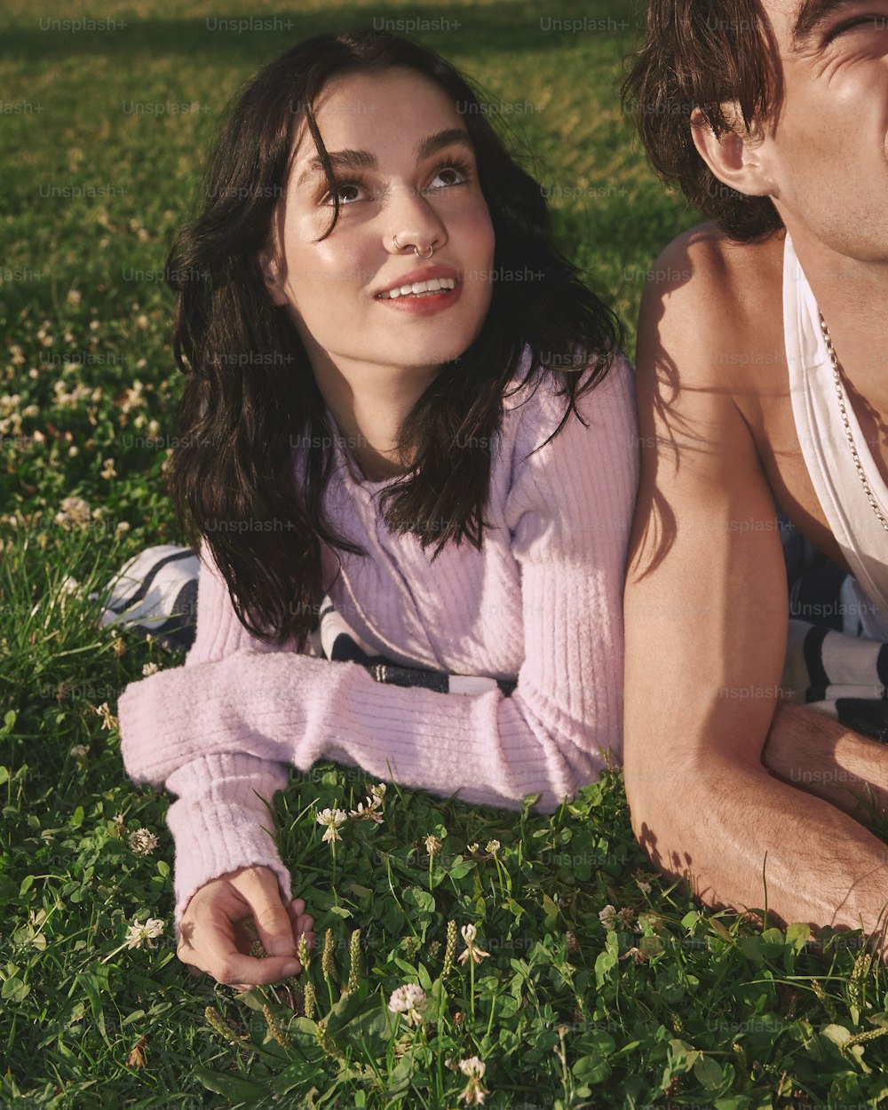 a man and a woman laying in the grass