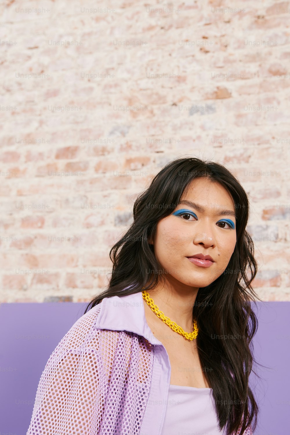 a woman wearing a purple shirt and a yellow necklace