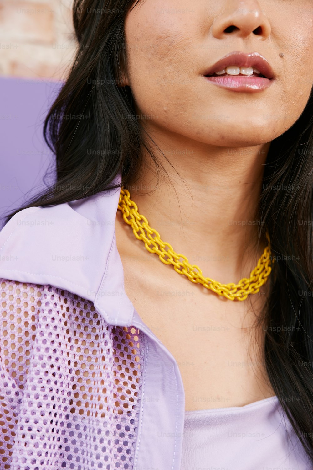a woman wearing a yellow chain necklace