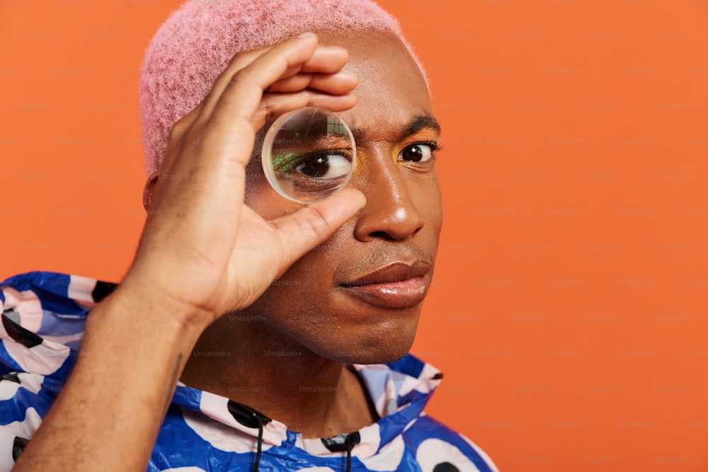 a man with a pink wig holding a magnifying glass