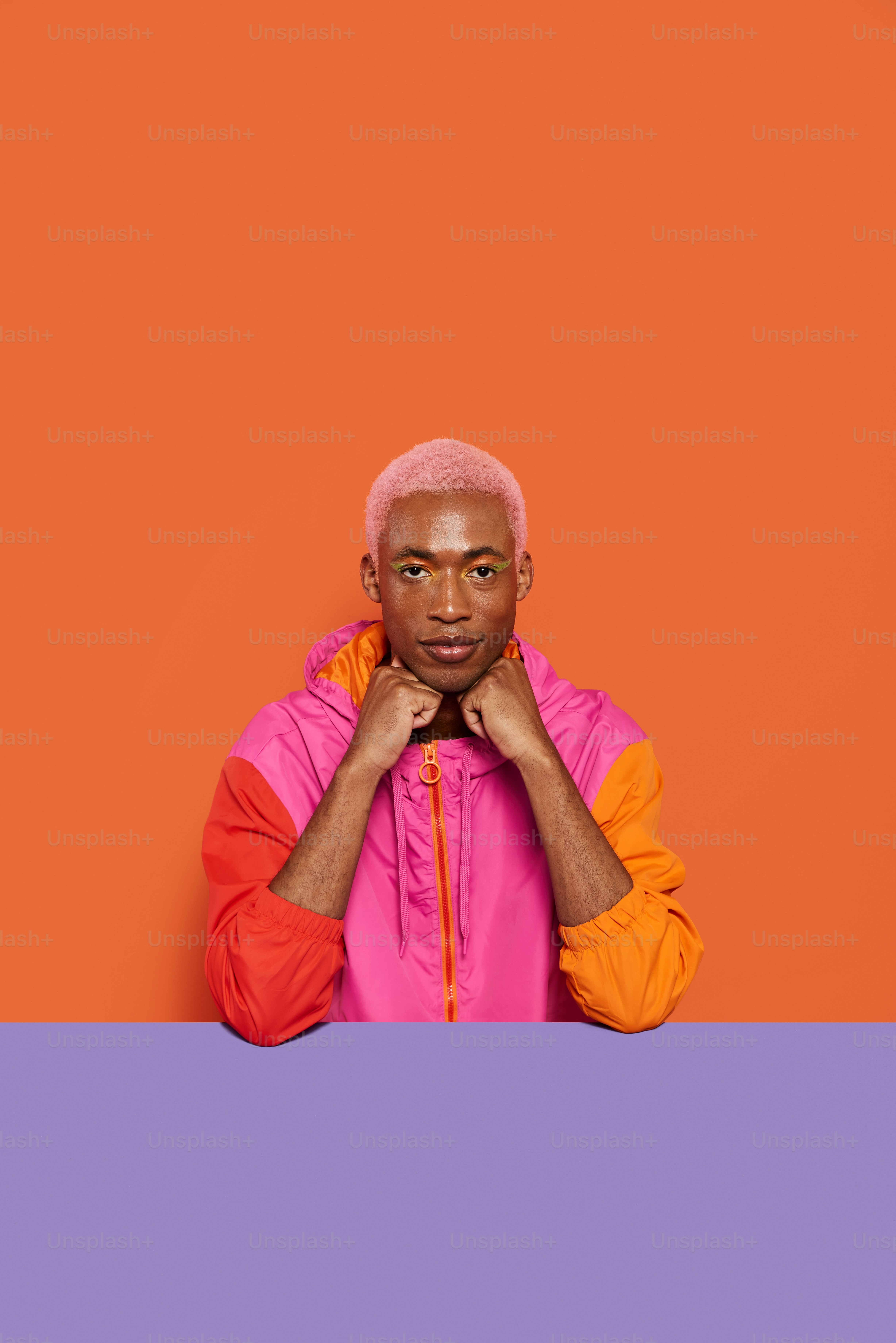 a man in a pink and orange jacket posing for a picture