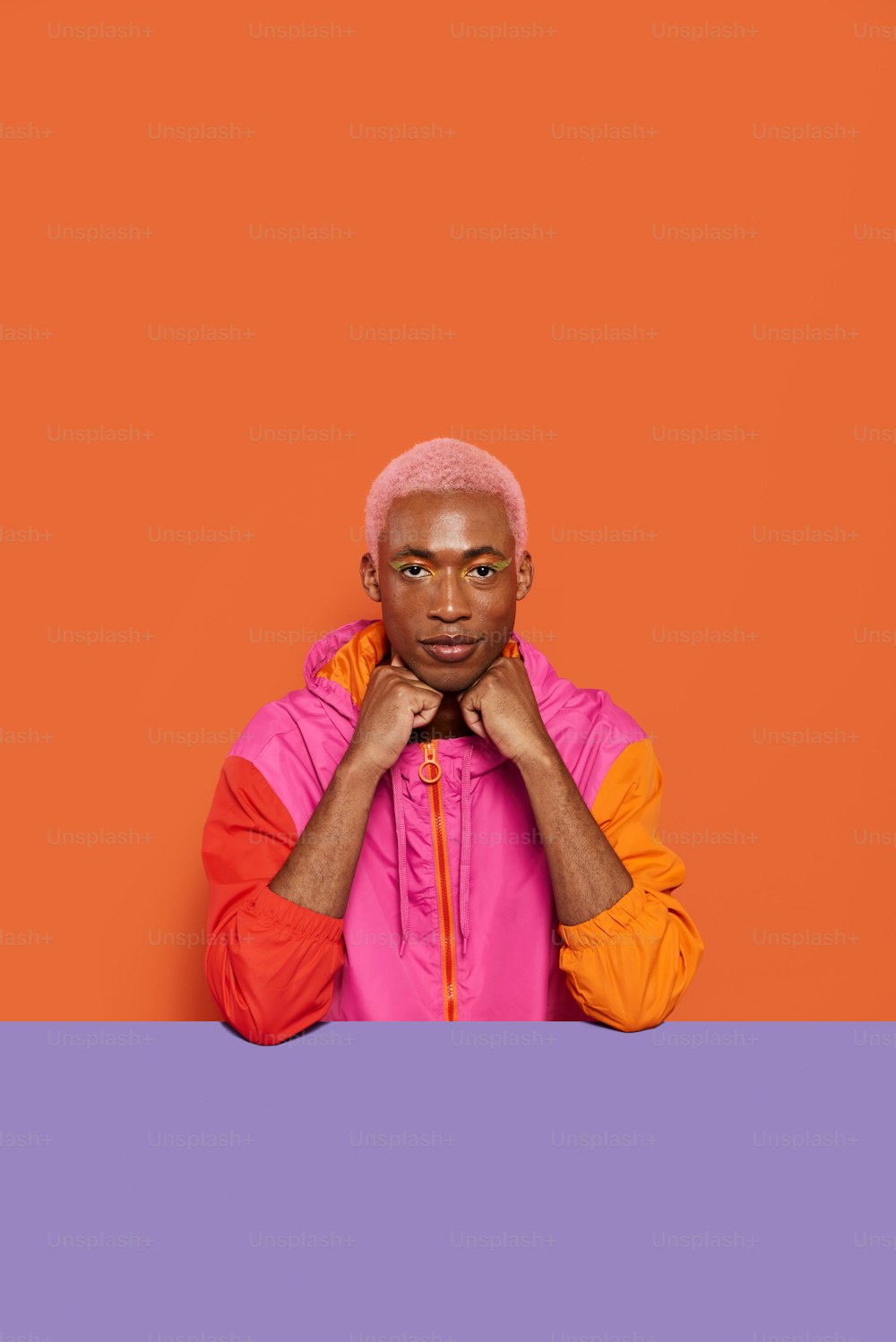 a man in a pink and orange jacket posing for a picture