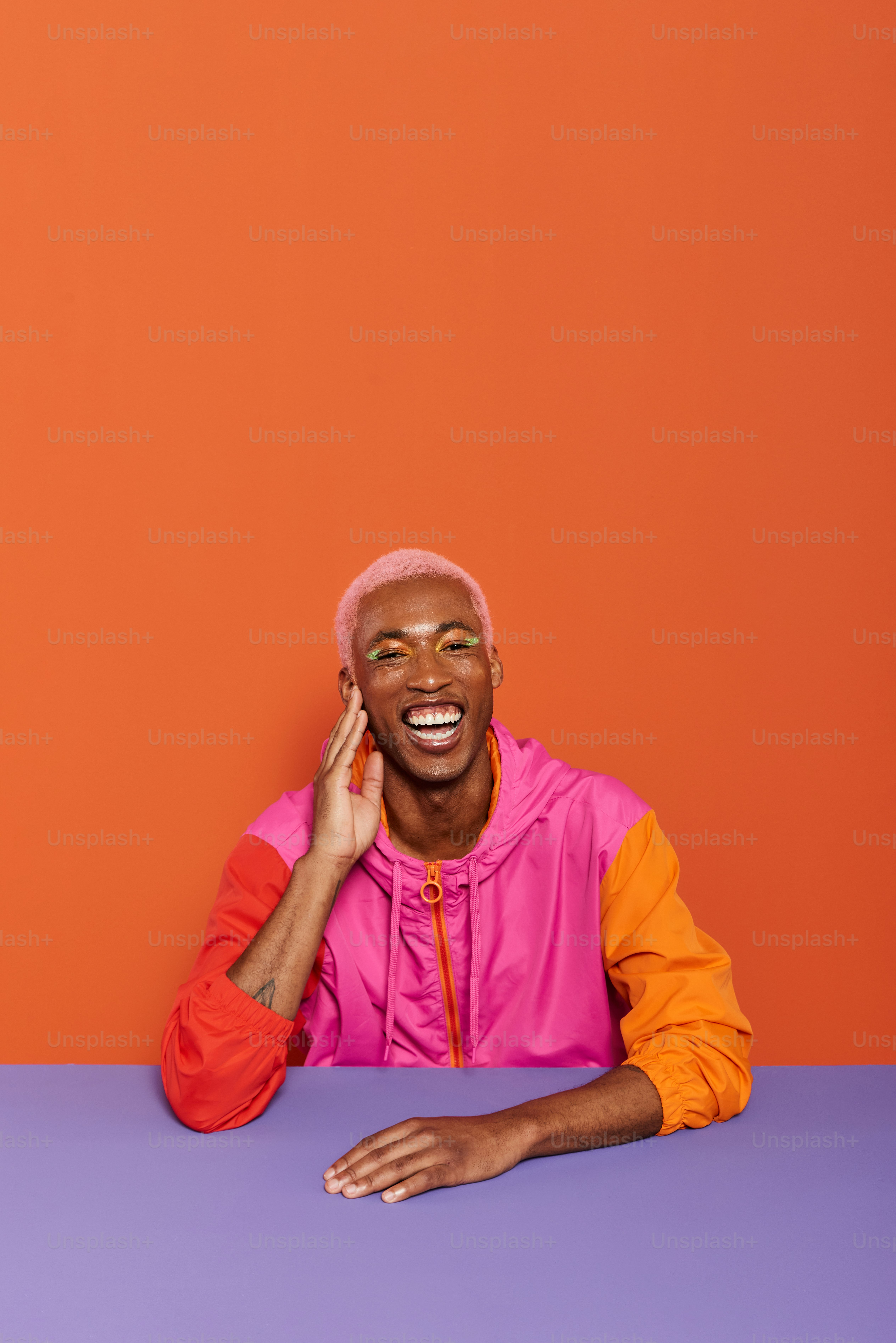 a man sitting at a table talking on a cell phone