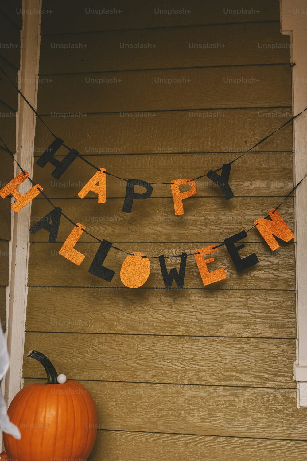 Un letrero que dice Feliz Halloween colgado en una casa