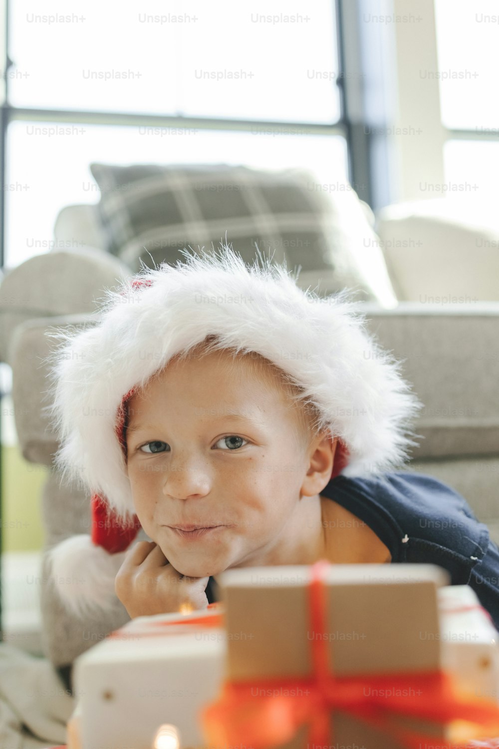 a young boy wearing a santa hat and holding a present