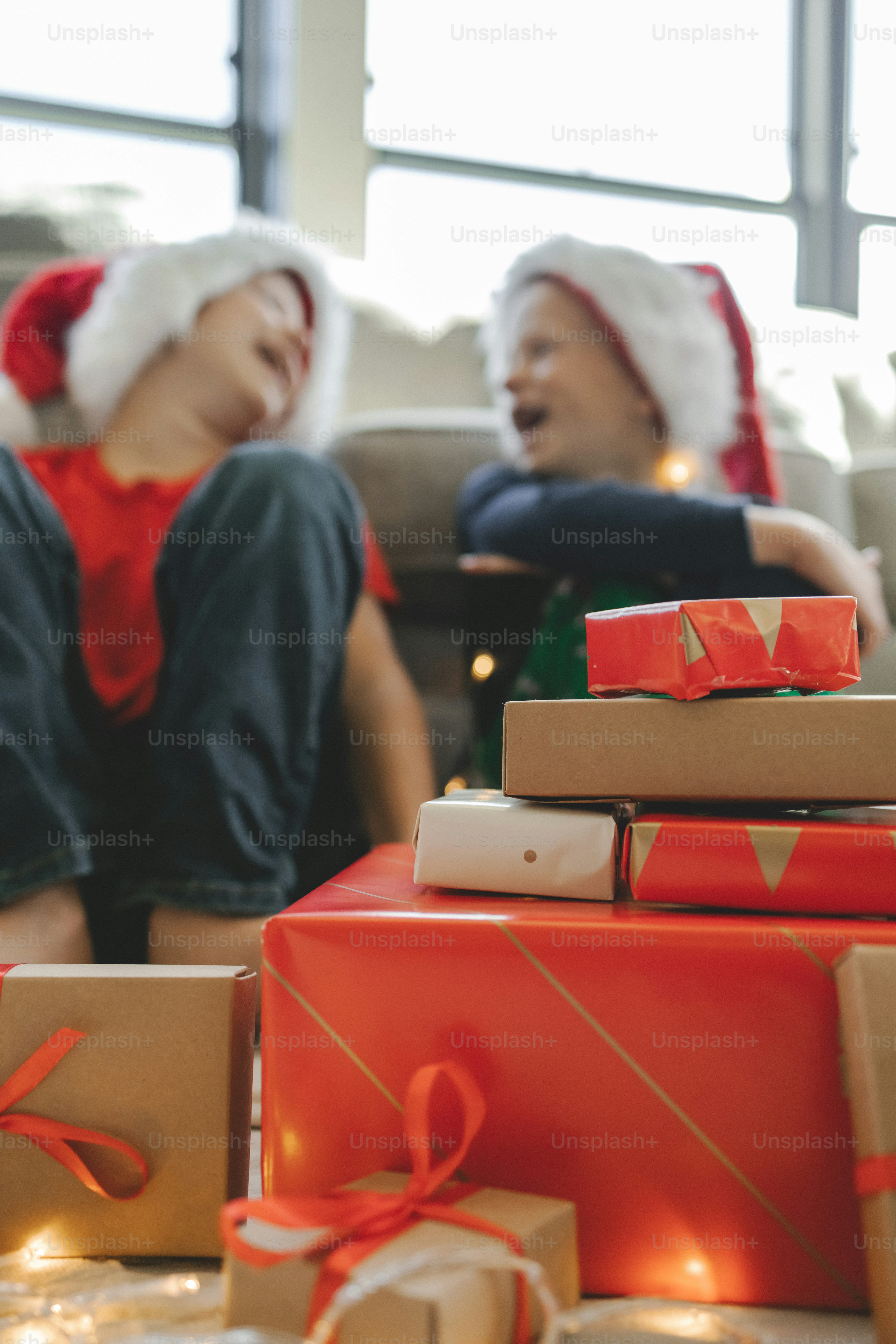 a couple of women sitting next to a pile of presents
