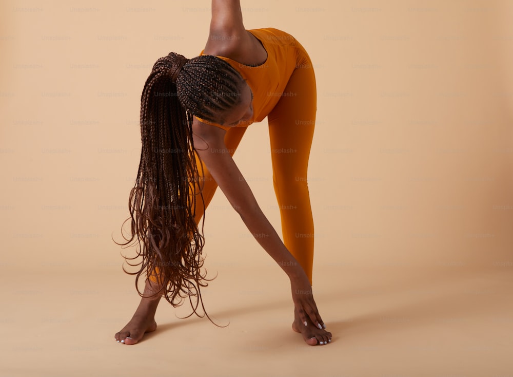 uma mulher fazendo um suporte de mão em uma posição de ioga
