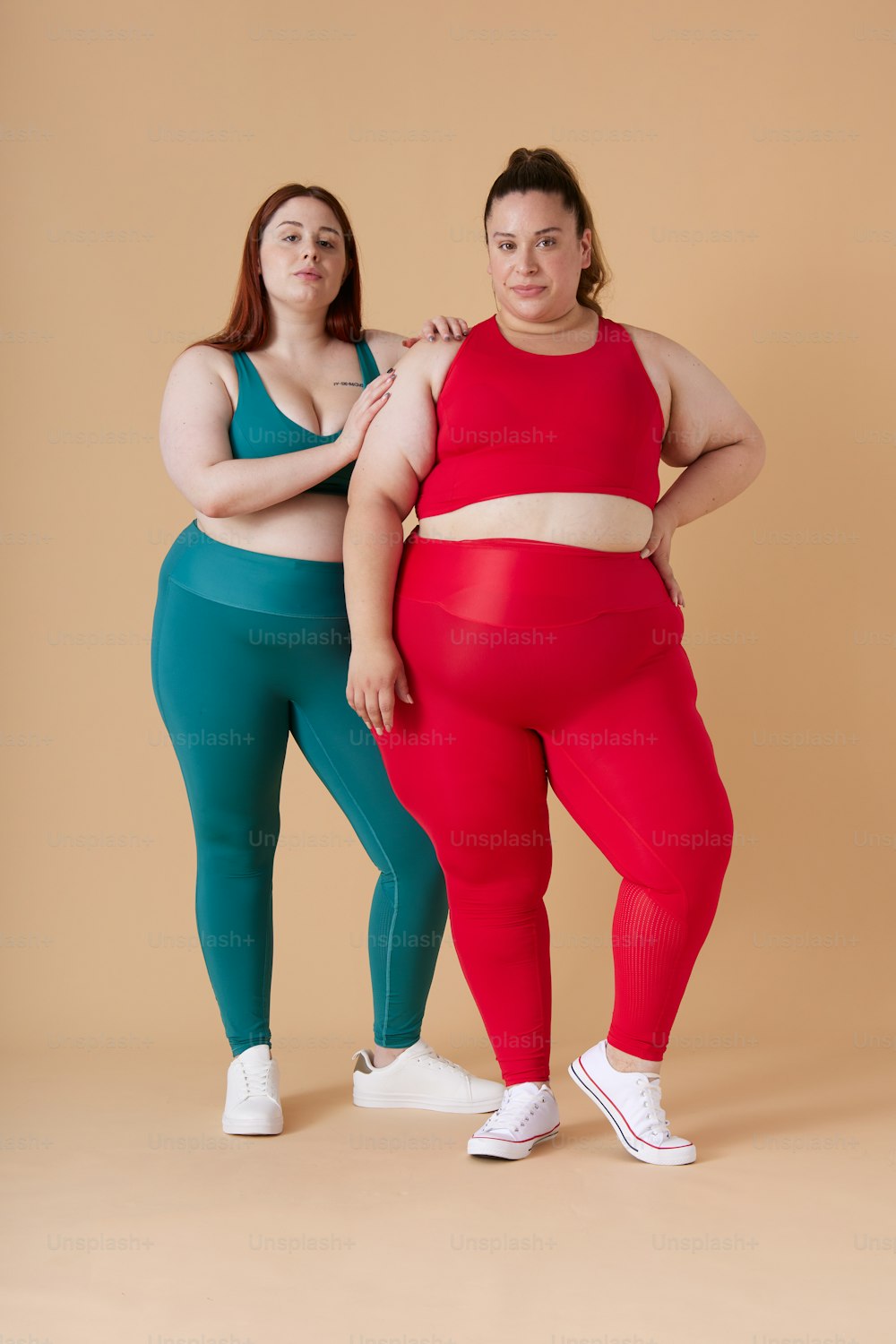 two women standing next to each other in matching outfits