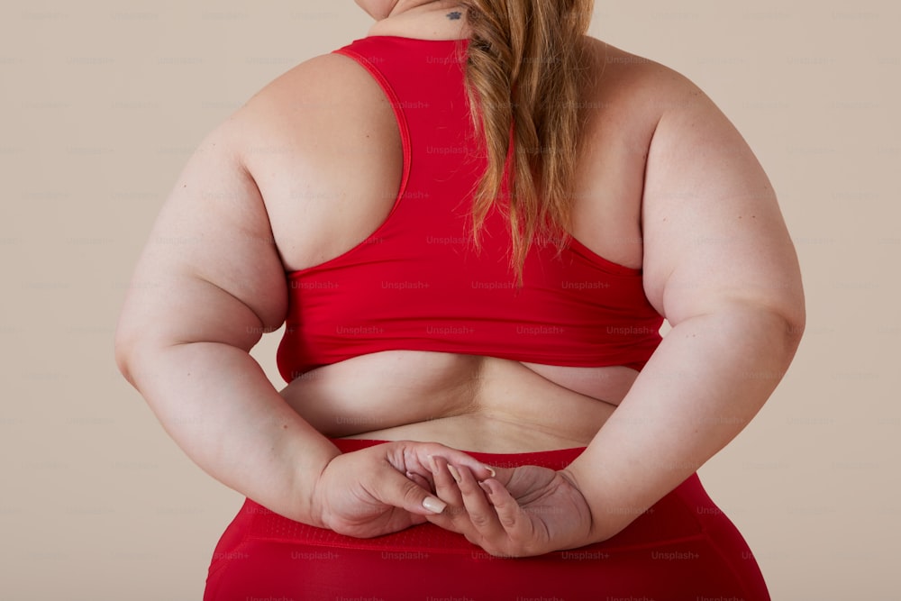 Una donna in un top rosso con le mani sui fianchi