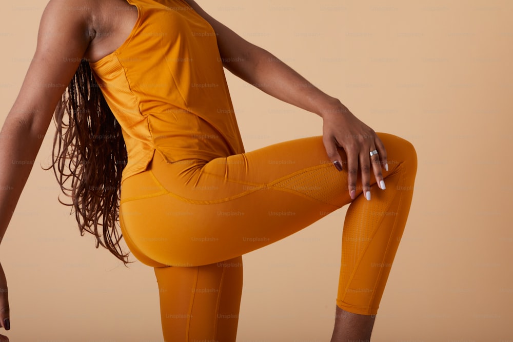 a woman in a yellow top and leggings