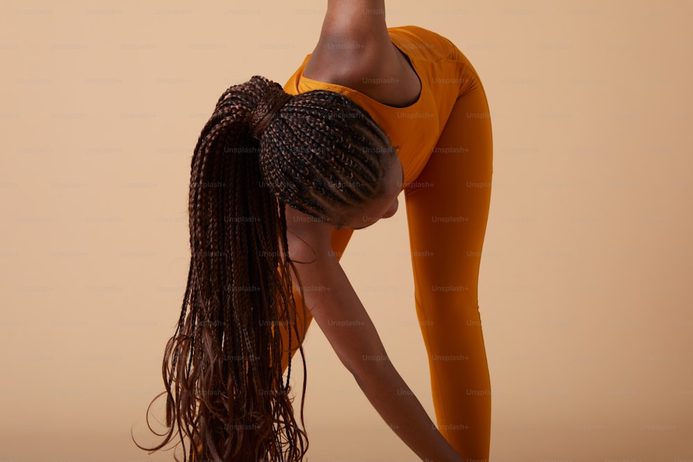 a woman doing a yoga pose with her hands behind her head