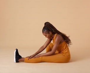 Una donna seduta a terra con le gambe incrociate