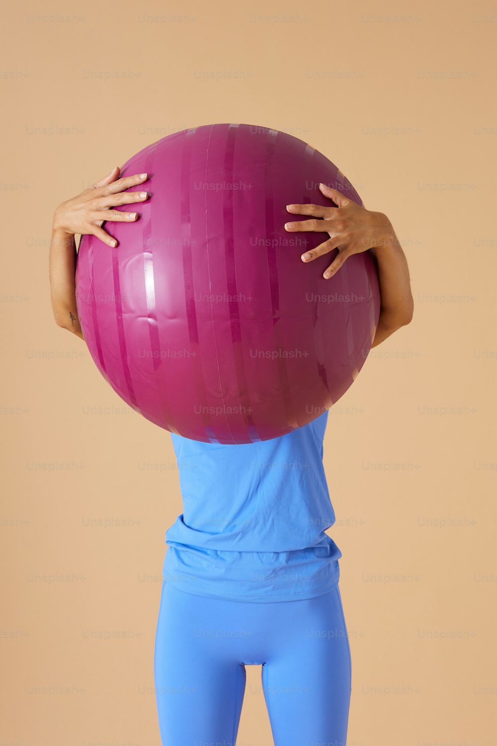 a woman is holding a large exercise ball