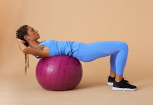 a woman is doing exercises on an exercise ball