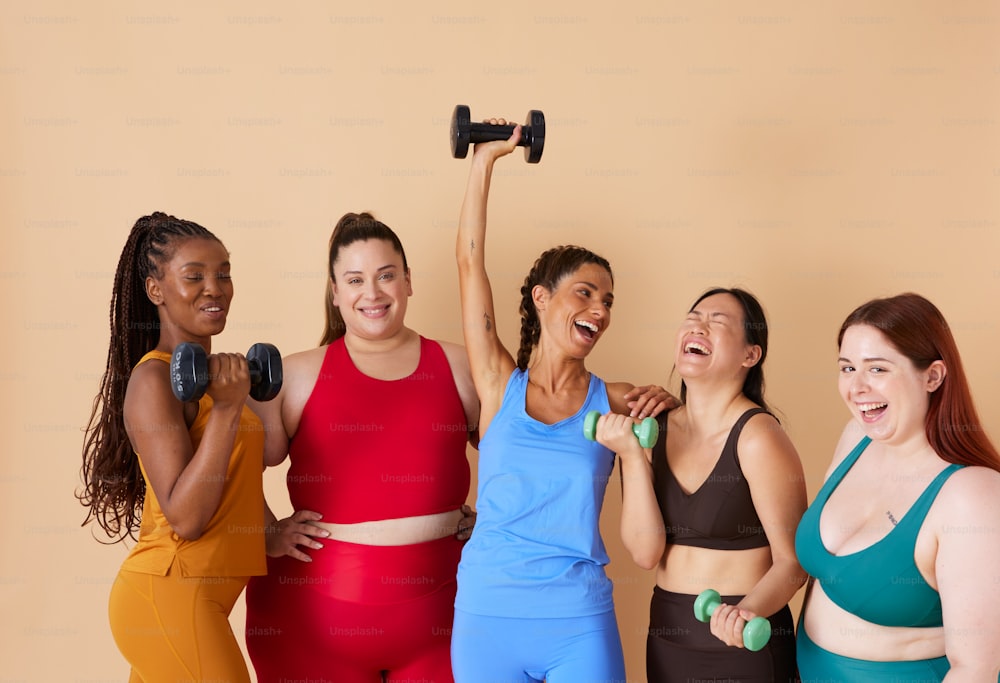 a group of women standing next to each other holding dumbs