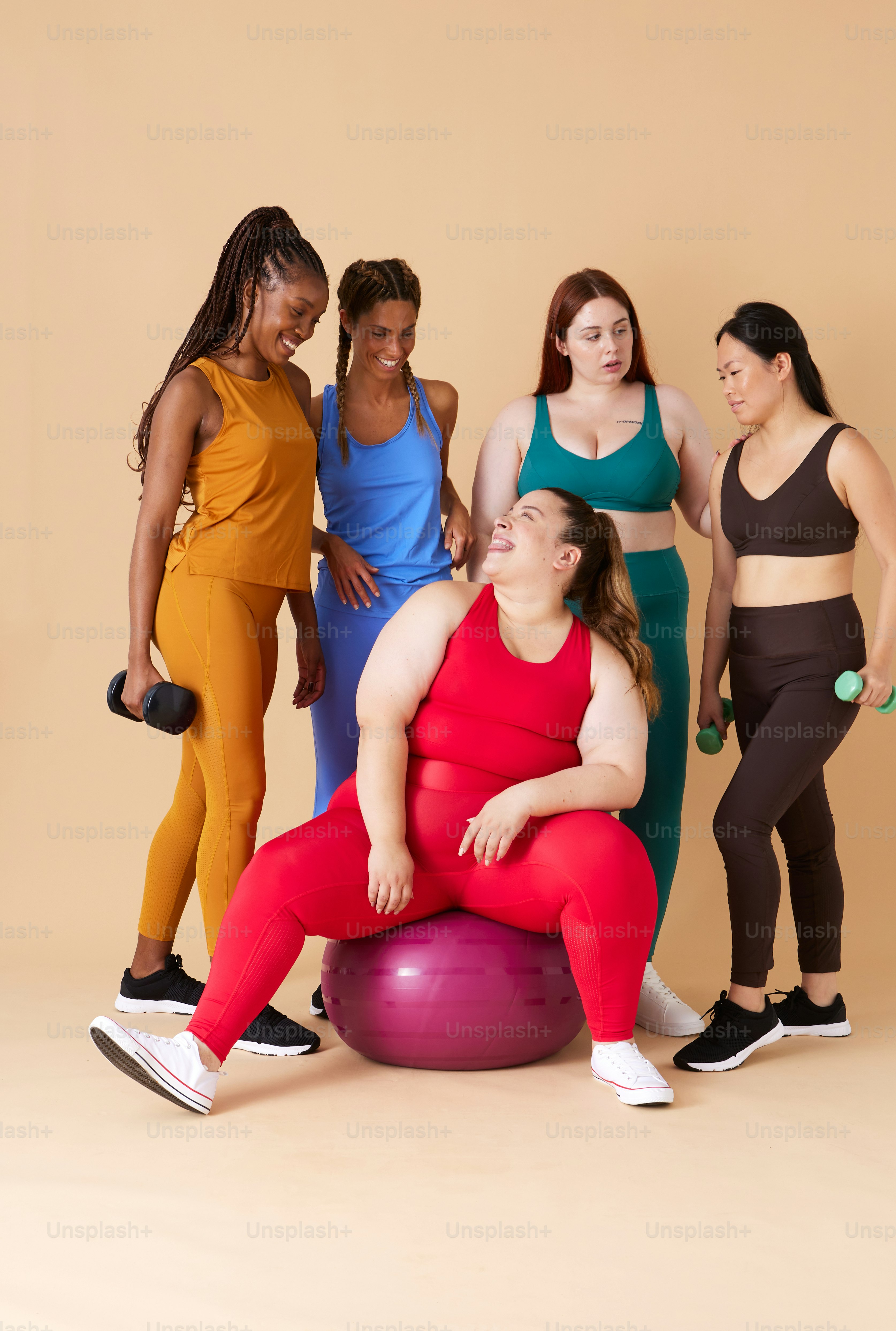 Un grupo de mujeres posando para una foto en una pelota de ejercicio